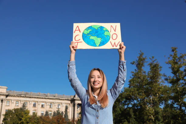 istock Young woman with poster protesting against climate change outdoors 1399558907