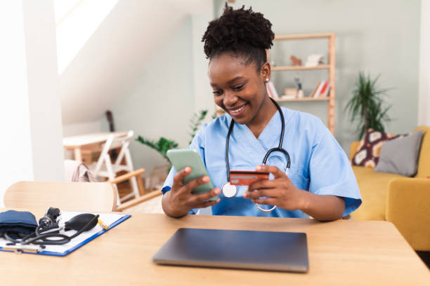 African American nurse shopping online after work stock photo