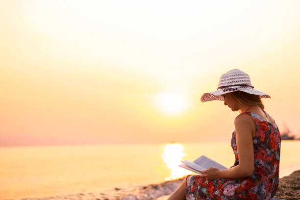 little girl reading book at tropical beach vacation