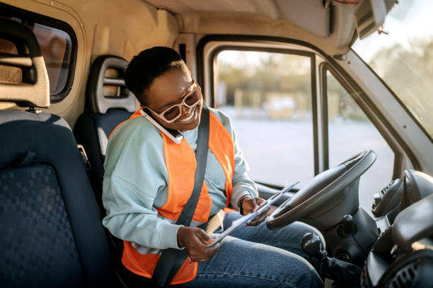 istock Female courier using phone inside of a delivery van 1399561678