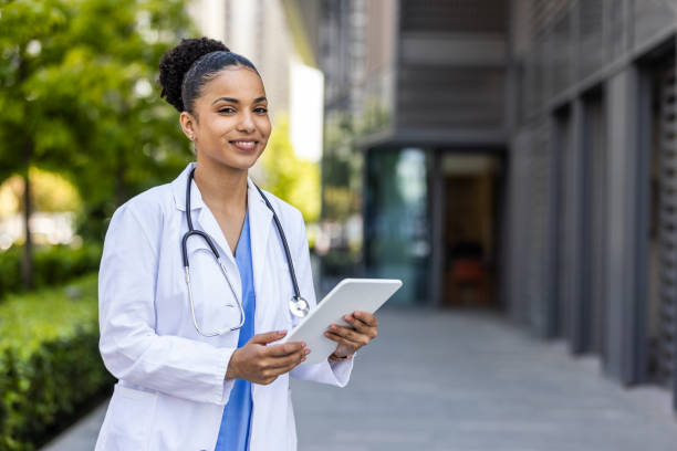 istock Female nurse or doctor smiles while holding digital tablet with electronic patient file 1399563048