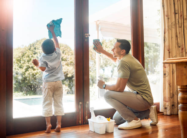 Little boy helping his father wash and wipe clean glass doors for household chores at home. Happy father and son doing spring cleaning together. Kid learning to be responsible by doing tasks Little boy helping his father wash and wipe clean glass doors for household chores at home. Happy father and son doing spring cleaning together. Kid learning to be responsible by doing tasks father housework stock pictures, royalty-free photos & images