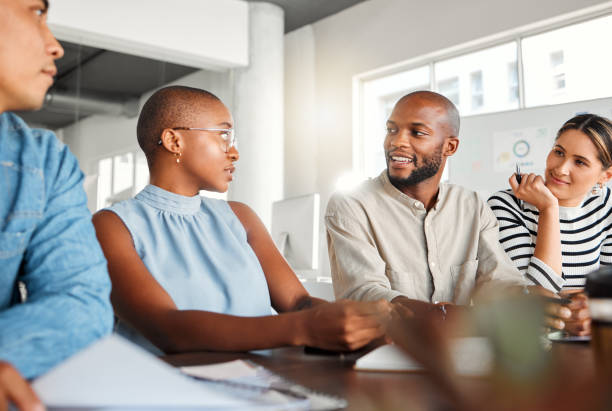 groupe de gens d’affaires sérieux et diversifiés ayant une réunion dans un bureau au travail. des professionnels parlent dans un bureau. gens d’affaires planifiant ensemble - serious african ethnicity mid adult bright photos et images de collection