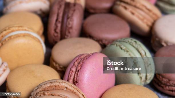 Full Frame Image Of Heap Of Multi Coloured Macarons Filled With Flavoured Butter Cream Vanilla Lemon Salted Caramel Chocolate Strawberry And Pistachio Flavoured Meringues Focus On Foreground Stock Photo - Download Image Now