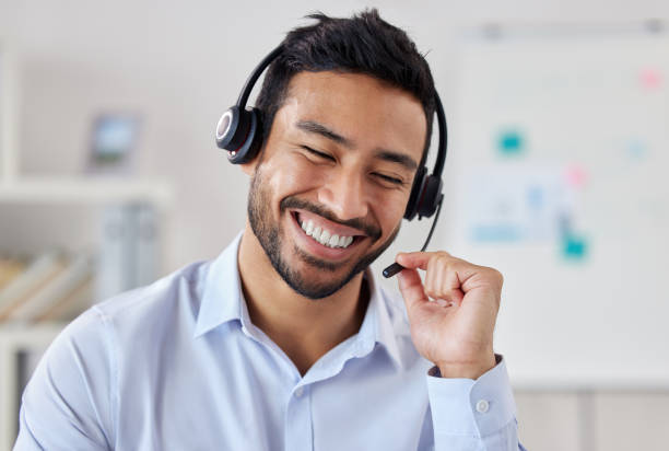 사무실에서 일하는 동안 헤드셋으로 이야기하는 큰 미소를 가진 행복한 혼합 레이스 콜 센터 텔레 마케팅 에이전트의 얼굴. 고객 서비스 영업 지원을위한 헬프 데스크를 운영하는 자신감있는 � - enterprise digital assistant 뉴스 사진 이미지