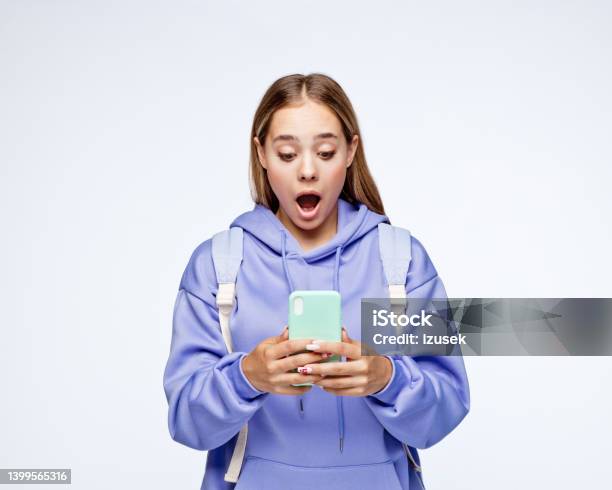 Surprised Teenage Girl Wearing Lilac Hoodie Stock Photo - Download Image Now - Teenager, Teenage Girls, Mobile Phone