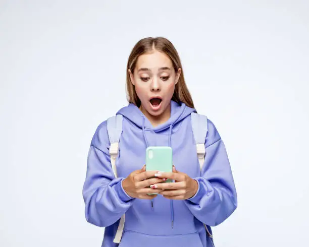 Photo of Surprised teenage girl wearing lilac hoodie