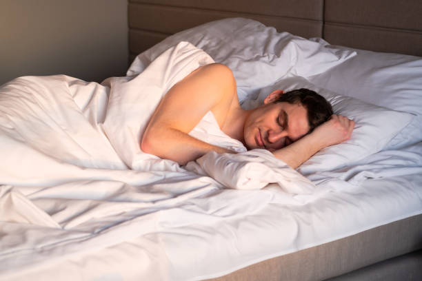 istock Handsome man sleeping in his bed in the sunny morning. 1399570822