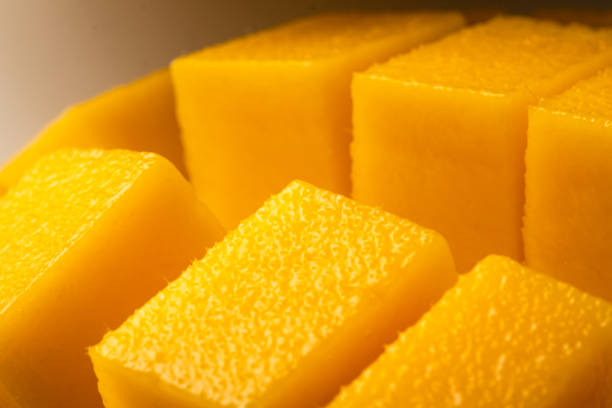 istock Juicy ripe yellow Thai mango on a white background. Hard light and shadow from a palm tree. 1399570926