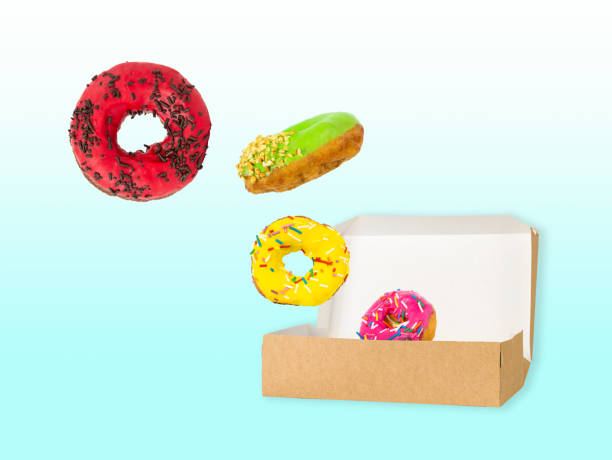 istock Donuts falling in paper box on blue background with copy space 1399572422