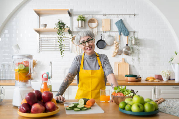 Portrait seniors Asian woman preparing to make fruit and vegetable juice in the kitchen. stock photo