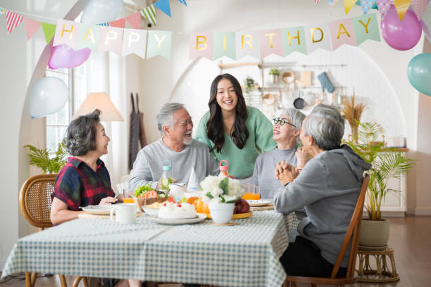 Group of Asian senior people having birthday party at home, celebrating birthday at retirement home with friends stock photo