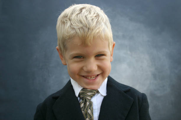 Blond grinning business boy stock photo