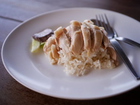 steamed rice topped with chicken ( Khao Mun Gai ), Thai food on a wooden table