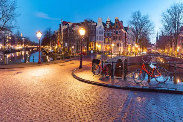 Amsterdam canal Keizersgracht with typical dutch houses and bridge during morning blue hour, Holland, Netherlands