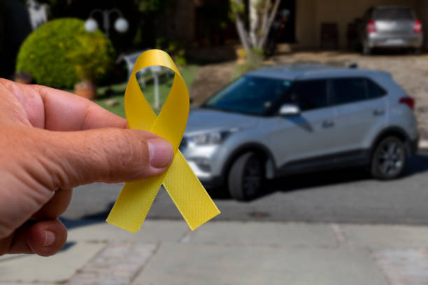 黄色は5月。黄色いリボンを持つ手。交通事故防止キャンペーン - young male ストックフォトと画像