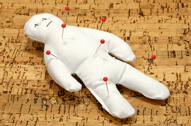 A white voodoo doll with five red pins in it Voodoo Doll With Pins revenge stock pictures, royalty-free photos & images