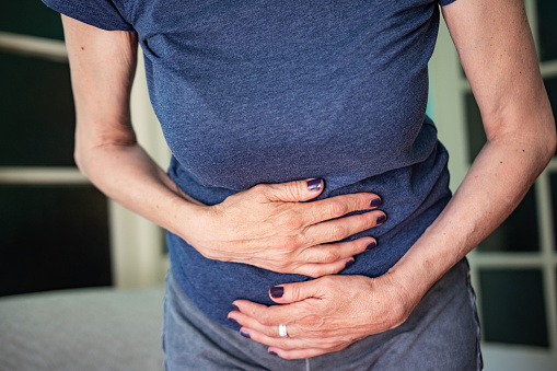 Shot of an unrecognizable mature woman suffering from stomach cramp