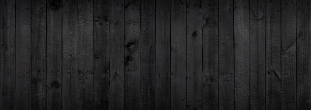 istock Black wood texture background coming from natural tree. The wooden panel has a beautiful dark pattern that is empty. 1399579981