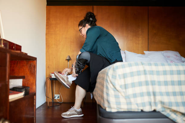 istock An amputee woman is taking off a shoo from her prosthetic leg. 1399581490