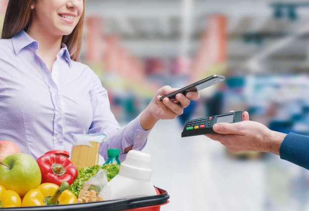 istock Woman paying for groceries using her smartphone 1399582729