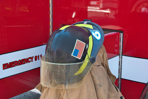 Fireman's helmet on brown coat by fire engine truck
