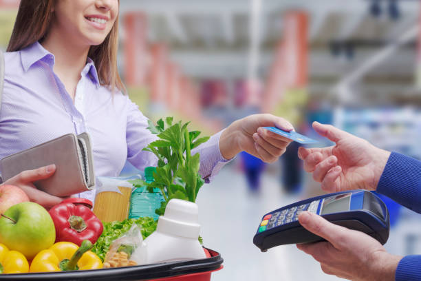 istock Woman paying for groceries using a credit card 1399582787