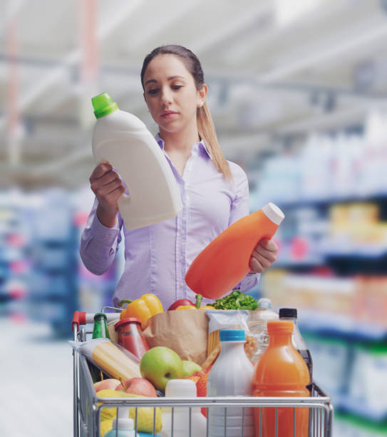 Woman comparing products at the supermarket stock photo