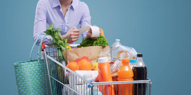 istock Woman checking a grocery receipt and pushing a trolley 1399583070