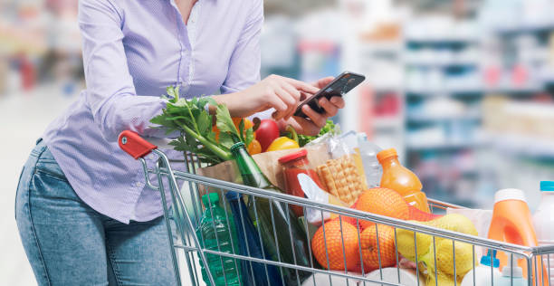 istock Woman using her smartphone at the supermarket 1399583138