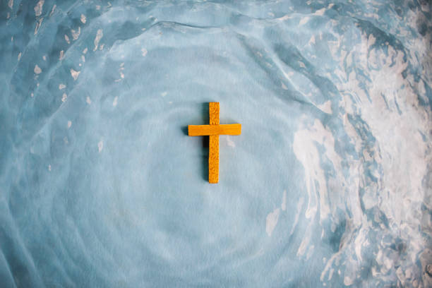 Wooden Cross surrounded with water Baptized by Christ Wooden Cross surrounded by moving water baptism stock pictures, royalty-free photos & images