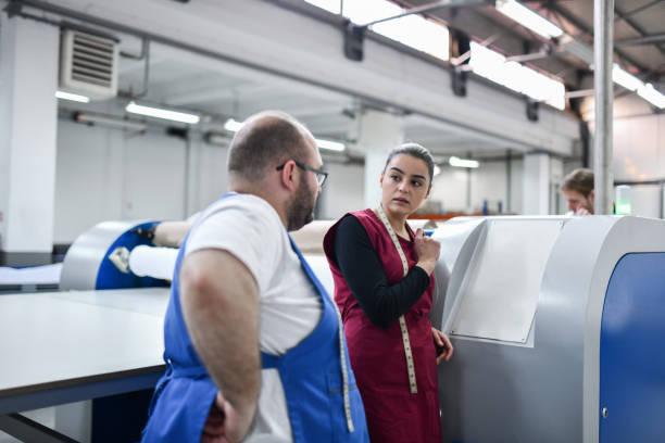 istock Male And Female Workers In Textile Factory Programming Printing Roller Machine 1399587673