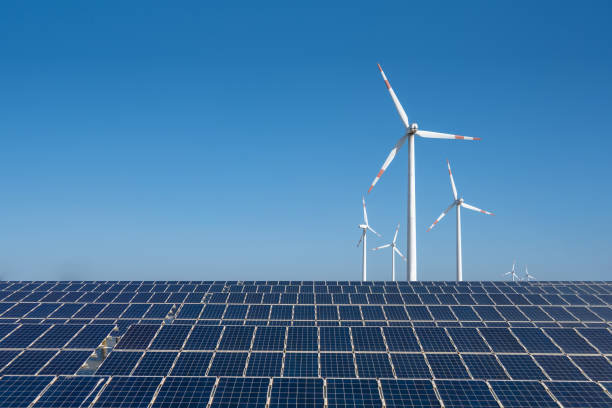 painéis solares fotovoltaicos e turbinas eólicas sob o céu azul - landscape alternative energy scenics farm - fotografias e filmes do acervo