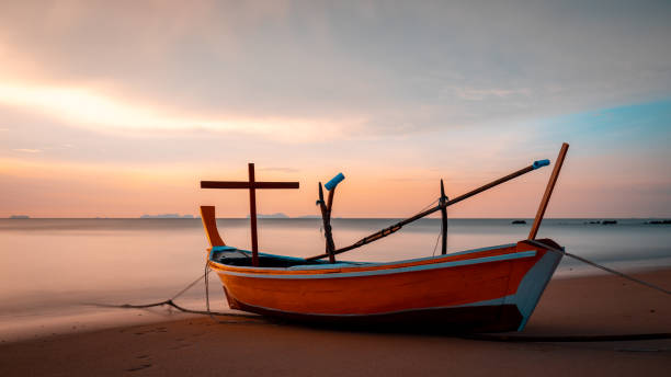 Fishing boat with cross with a tropical sunset