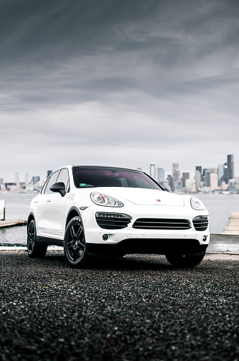 Seattle, WA, USA\n5/25/2022\nPorsche Cayenne parked next to the water with Seattle in the background
