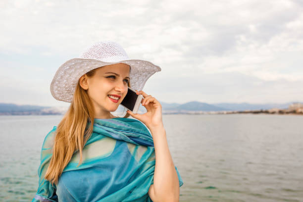 istock Women talking on a phone while walking by the sea 1399595251
