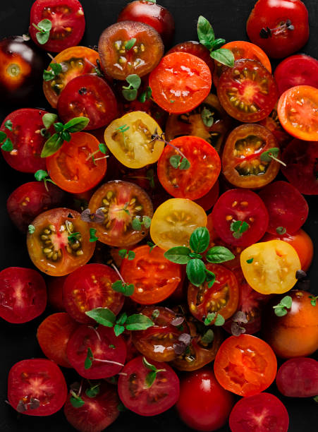 tomates cherry coloreados en rodajas, con albahaca, primer plano, vista superior, sin gente, papel tapiz de comida, - cherry tomato fotografías e imágenes de stock