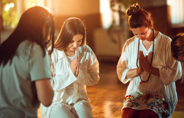 istock Women practicing meditation and praying indoors 1399597554