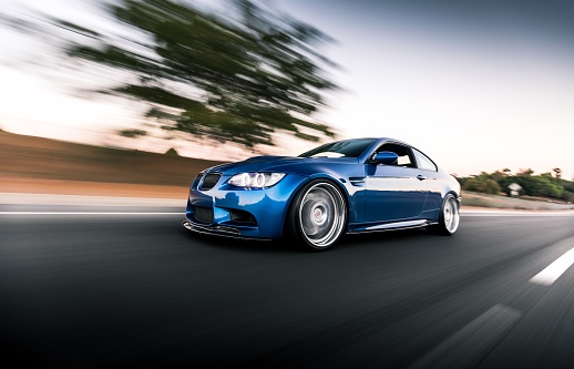 Seattle, WA, USA\nMarch 24, 2022\nBlue BMW M3 driving on the road with a clear sky overhead