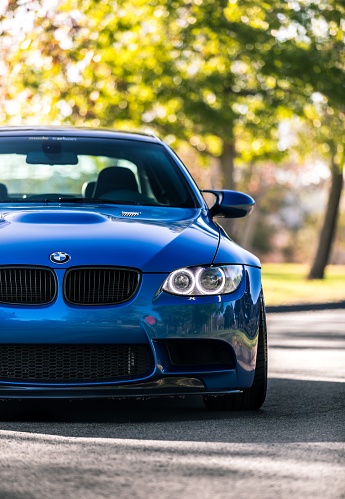 Seattle, WA, USA\nMarch 24, 2022\nBlue BMW M3 parked with a head on shot with a tree in the background
