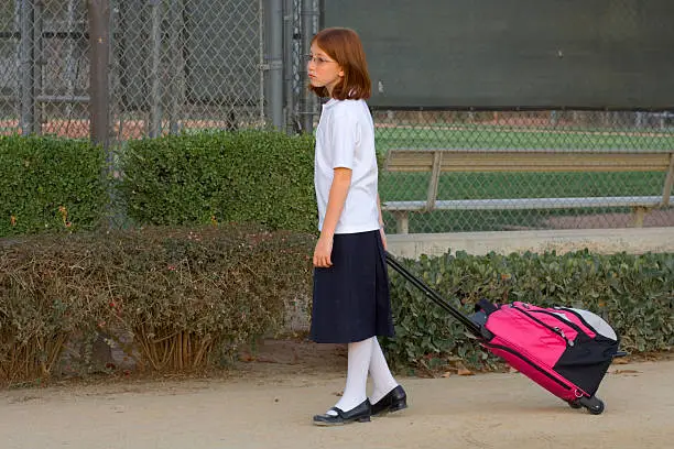Photo of schoolgirl with trolley bag
