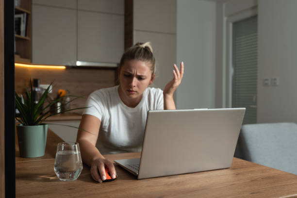 Young college or freelancer business woman working from home have issue with broken computer mouse for her laptop. Female can't do her homework because her mouse not working. Selective focus stock photo