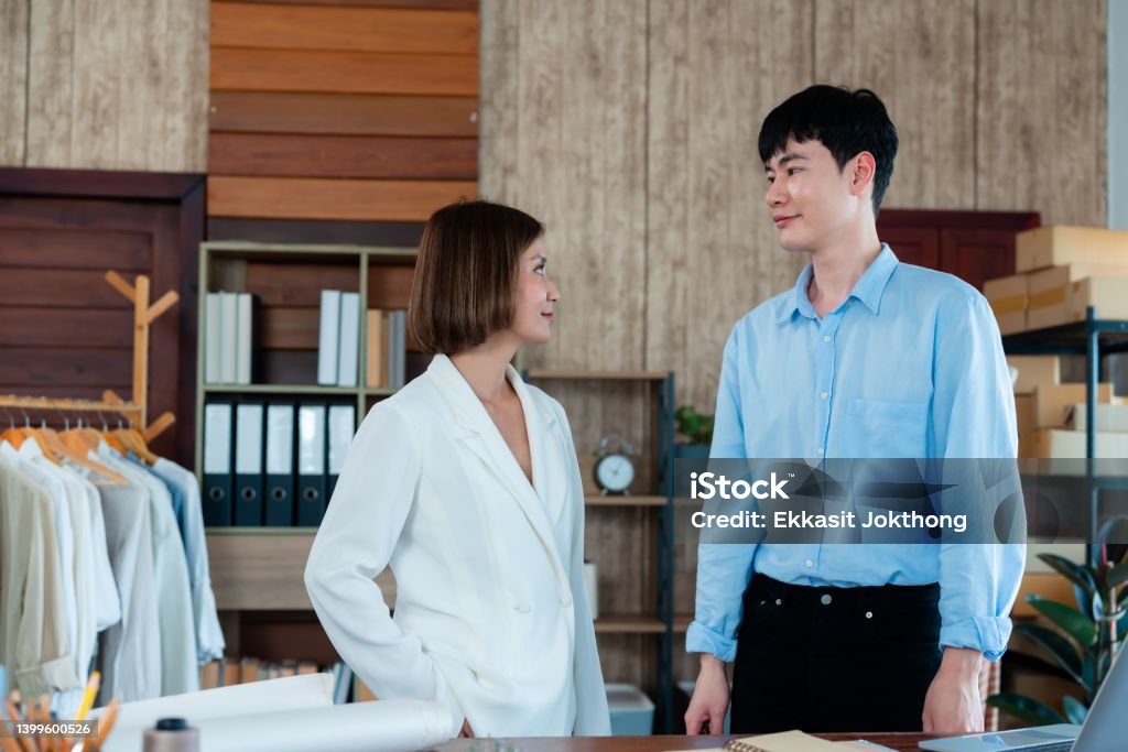 Young LGBTQ Asian Men and woman Small Business Partner,A close-up of the hands of the two designers holding hands for a collaboration,Professional Design clothes to sell online. 25-29 Years Stock Photo