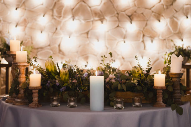 istock Table setting at the wedding reception. Floral compositions with beautiful flowers and greenery, candles, laying and plates on a decorated table. 1399601222