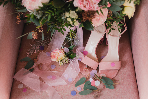 Bridal shoes with the wedding bouquet in the background, selective focus