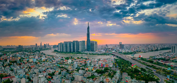 Aerial sunset view at Landmark 81 - it is a super tall skyscraper and Saigon bridge with development buildings along Saigon river light smooth down. Travel and landscape concept.