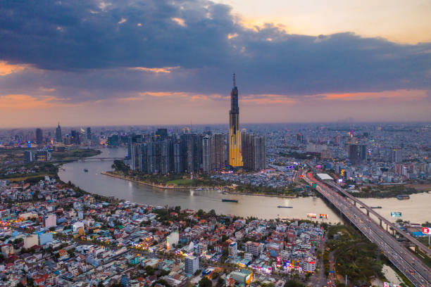 istock Aerial sunset view at Landmark 81 - it is a super tall skyscraper and Saigon bridge with development buildings along Saigon river light smooth down. 1399601711