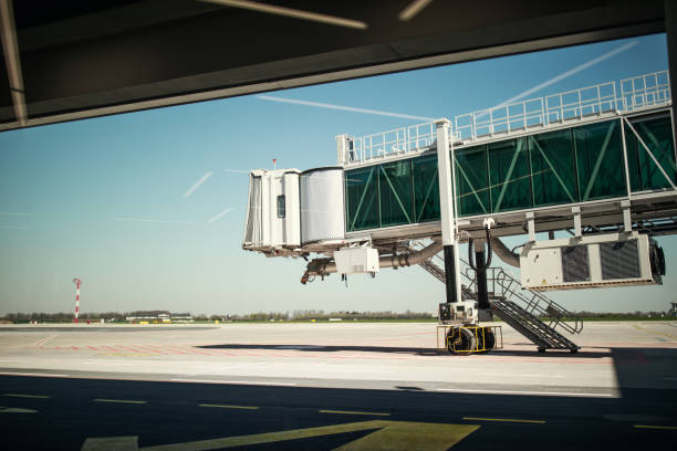 Airport gate with a view on vacant air bridge and apron without airplanes and passengers