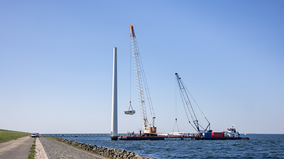 Lelystad, The Netherlands - April 22, 2022: Crane ship lifting gondola for demolition offshore wind turbine farm