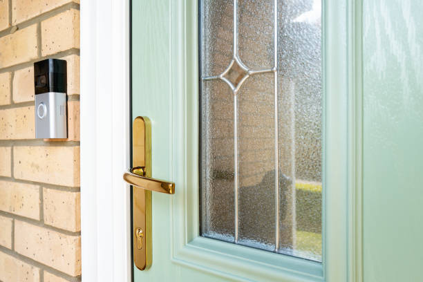 Newly installed high quality composite front door with double glazing and ornate brass door handle and lock. Newly installed high quality composite front door with double glazing and ornate brass door handle and lock. Also seen is a WiFi Smart DoorBell in the porch area. key doormat stock pictures, royalty-free photos & images